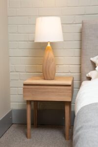 ark wooden bedside table with teardrop lamp and white conical shade