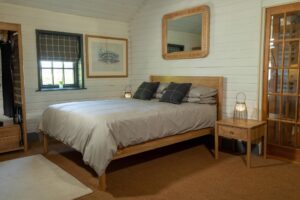 guest bedroom range - oiled oak - guest bed, bedside table and open wardrobe - shown with cleopatra mirror and portman lantern