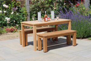 antibes 135cm outdoor table with 116cm outdoor bench - plantation teak. Shown with solstice candleholders.